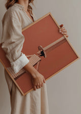 Cuadro decorativo de estilo minimalista y ilustración colocado en salón, mujer urbana surrealista en tonos terracota, modelo City girl