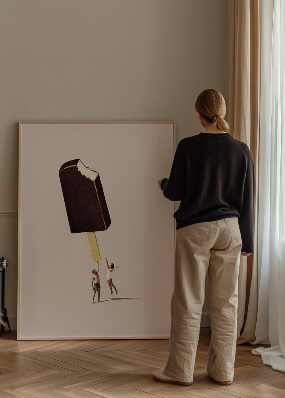 Gerahmtes Wandbild mit angebissenem Schokoladeneis, hellrosa Hintergrund, zwei kleinen menschlichen Figuren und surrealem Illustrationsstil in Braun-, Beige- und Rosatönen. Erhältlich auf kudeko.com