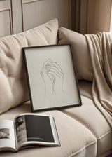 Wandbild mit zwei verschlungenen Händen in feinen schwarzen Linien auf hellbeigem Hintergrund, klare Komposition, sanfte Wirkung und minimalistischer Stil. Erhältlich auf kudeko.com