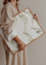 Cuadro decorativo de estilo minimalista y orgánico colocado en salón, hojas abstractas en tonos beige y dorado, modelo Abstract Golden Leaves