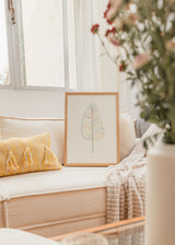 Cuadro decorativo de estilo minimalista y orgánico colocado en salón, hoja de plátano en líneas multicolor, modelo Banana Rainbow Leaf