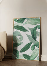 Cuadro decorativo de estilo minimalista y orgánico colocado en salón, hojas tropicales en tonos verdes suaves, modelo Hojas Sueltas