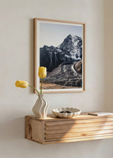 Tableau encadré représentant une montagne enneigée, sommet rocheux, pentes sombres, glacier visible, chemin courbe et tons gris, blanc et brun, dans un style nature et paysage raffiné. Disponible sur kudeko.com