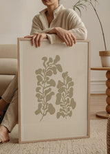 Tableau avec composition botanique de deux tiges aux feuilles organiques arrondies beige taupe sur fond crème, dans un style minimaliste et contemporain. Disponible sur kudeko.com