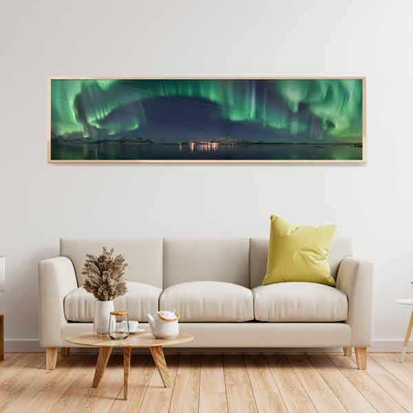 Quadro horizontal com aurora boreal verde e turquesa sobre lago escuro, céu noturno azul, montanhas nevadas, reflexos de luz e estilo de natureza paisagística. Disponível em kudeko.com