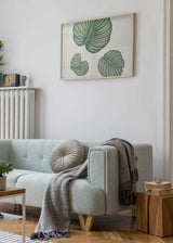 Horizontales Wandbild mit drei großen tropischen Blättern in Salbeigrün auf weißem Hintergrund, hellen Blattadern, ausgewogener botanischer Komposition und modernem Naturstil. Erhältlich auf kudeko.com