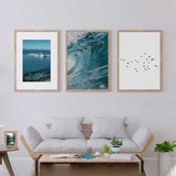 Gerahmtes Wandbild mit schwarzem Vogelschwarm im Flug auf weitem weißem Hintergrund, elegantem Kontrast, luftiger Komposition und minimalistischem Stil. Erhältlich auf kudeko.com