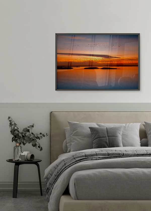 Tableau horizontal avec coucher de soleil sur l’eau, vols d’oiseaux, îles en silhouette, ciel orange, doré et bleu doux, style photographique apaisant. Disponible sur kudeko.com