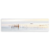 Cuadro horizontal de barca lejana sobre agua tranquila con cañas finas, tonos blanco, beige, gris y marrón, de estilo fotográfico. Disponible en kudeko.com