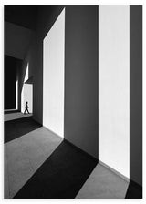 Cuadro de arquitectura en blanco y negro con grandes muros, luz intensa, sombras largas y figura humana pequeña, de estilo fotográfico. Disponible en kudeko.com