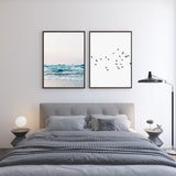 Gerahmtes Wandbild mit ruhigem Meer, sanften Wellen am Ufer, hellem Sand, lichtdurchflutetem Himmel sowie Türkisblau, Weiß und Beige in fotografischem Stil. Erhältlich auf kudeko.com