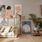 Gerahmtes Wandbild mit sitzender weiblicher Figur von hinten, weißem Kleid mit korallfarbenen Punkten, dunklem Haar, beigem Hintergrund und illustrativem Stil. Erhältlich auf kudeko.com