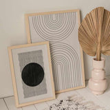 Cuadro con arcos concéntricos negros sobre fondo beige claro, composición simétrica de líneas limpias y estilo geométrico contemporáneo. Disponible en kudeko.com