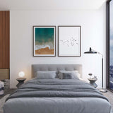 Tableau avec vue aérienne d’une côte, mer turquoise et vert profond, écume blanche, sable beige chaud, composition sereine au style photographique lumineux. Disponible sur kudeko.com