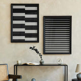 Gerahmtes Wandbild mit Stufenmuster in Schwarz und Weiß, schwarzen Blöcken, weißen Streifen und modernem geometrischem Stil für die Wandgestaltung. Erhältlich auf kudeko.com