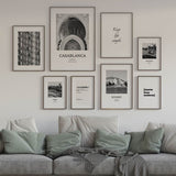 Cuadro con arco monumental de arquitectura marroquí, relieves ornamentales, mosaicos geométricos y tonos blanco, gris y negro, de estilo fotográfico. Disponible en kudeko.com