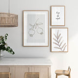 Cuadro de dos granadas colgando de una rama con hojas, en tonos gris topo sobre fondo claro, de estilo minimalista. Disponible en kudeko.com