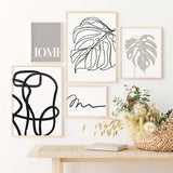 Cuadro con la palabra HOME en letras blancas grandes sobre fondo beige grisáceo liso, composición limpia de estilo con frases. Disponible en kudeko.com