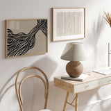 Horizontales Wandbild mit schwarzen, welligen Linien auf beigem Hintergrund, organisches abstraktes Motiv, klarer Kontrast und moderner Stil für die Wandgestaltung. Erhältlich auf kudeko.com