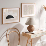 Quadro horizontal com forma orgânica preta, blocos brancos sobrepostos, fundo bege suave e linha curva fina, num estilo minimalista equilibrado. Disponível em kudeko.com