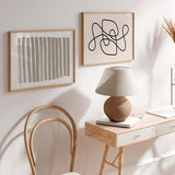Quadro horizontal com linhas pretas contínuas entrelaçadas, formas curvas abstratas, fundo bege claro e estilo minimalista para decoração de parede contemporânea. Disponível em kudeko.com