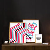 Cuadro con composición geométrica de la palabra LOVE repetida en bloques tridimensionales, en rosa fucsia, azul celeste, rojo y negro sobre fondo blanco, de estilo geométrico. Disponible en kudeko.com