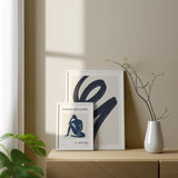 Cuadro con silueta femenina sentada en azul marino, fondo beige claro y tipografía negra, de estilo minimalista. Disponible en kudeko.com