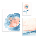 Conjunto de tres cuadros con flor grande azul y rosa, lámina botánica de flor coral con hojas azules y composición suave en tonos pastel, de estilo floral. Disponible en kudeko.com