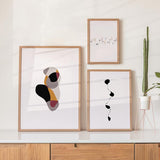 Set aus drei gerahmten Wandbildern mit abstrakten organischen Formen, Typografie simplicity, minimalistischer fließender Linie, in Schwarz, Beige, Terrakotta und Bordeaux, mit ruhigem abstraktem Stil. Erhältlich auf kudeko.com