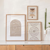 Conjunto de tres cuadros con formas abstractas en beige, arena y marrón, con arcos, círculos, puntos decorativos y líneas finas, de estilo minimalista. Disponible en kudeko.com