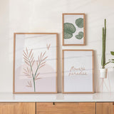 Ensemble de trois tableaux avec feuilles tropicales vert sauge, branche botanique rose poudré, texte flowers paradise, fond blanc et style minimaliste contemporain. Disponible sur kudeko.com