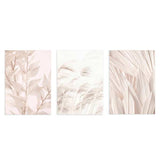 Set aus drei Wandbildern mit Blättern, Gräsern und ornamentalem Blattwerk in Beige, Sand und Elfenbein, mit sanfter botanischer Komposition im Natur- und Landschaftsstil. Erhältlich auf kudeko.com