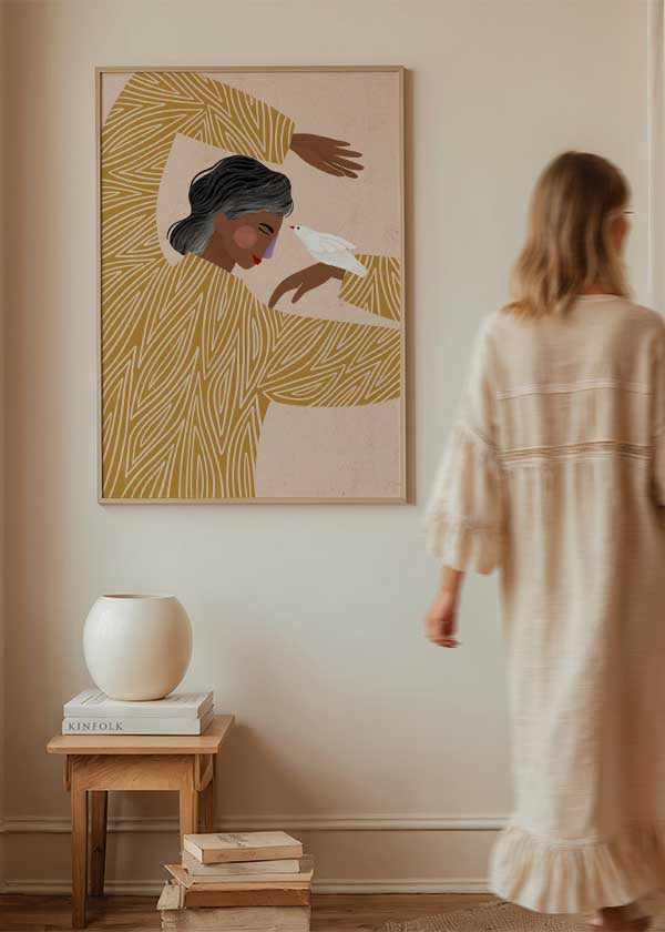 Cuadro ilustrado colorido con mujer de jersey mostaza y pájaro blanco Bea Muller, kudeko.com

