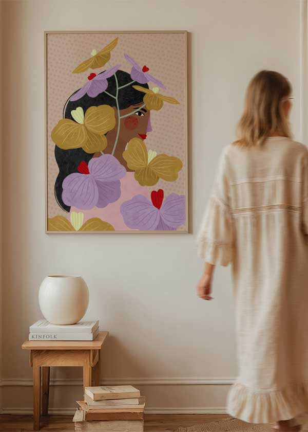 Cuadro ilustrado colorido con retrato femenino rodeado de flores doradas y lilas, obra de Bea Muller, kudeko.com
