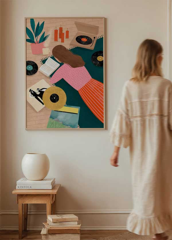 Cuadro ilustrado colorido con mujer leyendo rodeada de vinilos y tocadiscos, obra de Bea Muller, kudeko.com

