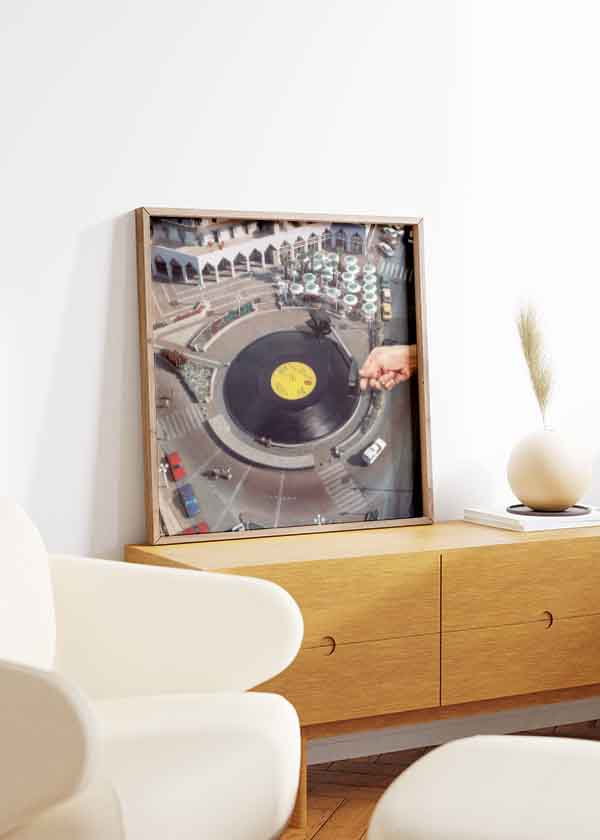 Cuadro surrealista de una plaza convertida en vinilo con aguja de tocadiscos, disponible en kudeko.com.
