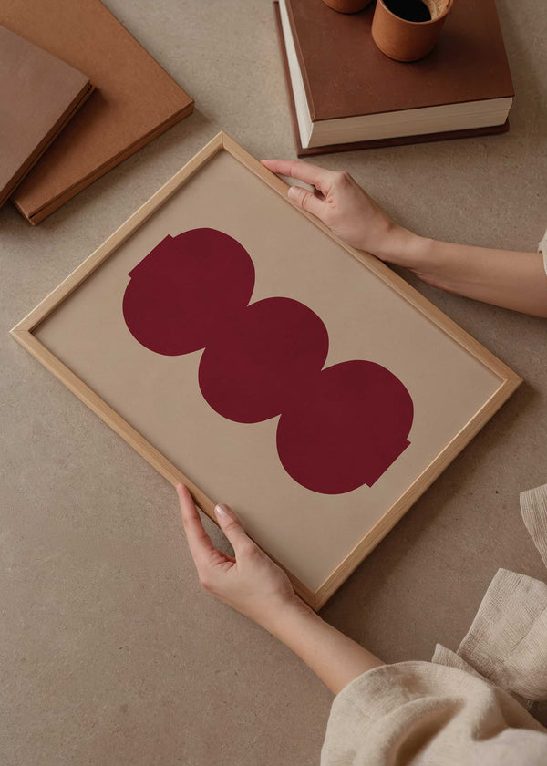 Cuadro geométrico con formas circulares burdeos sobre fondo beige, kudeko.com
