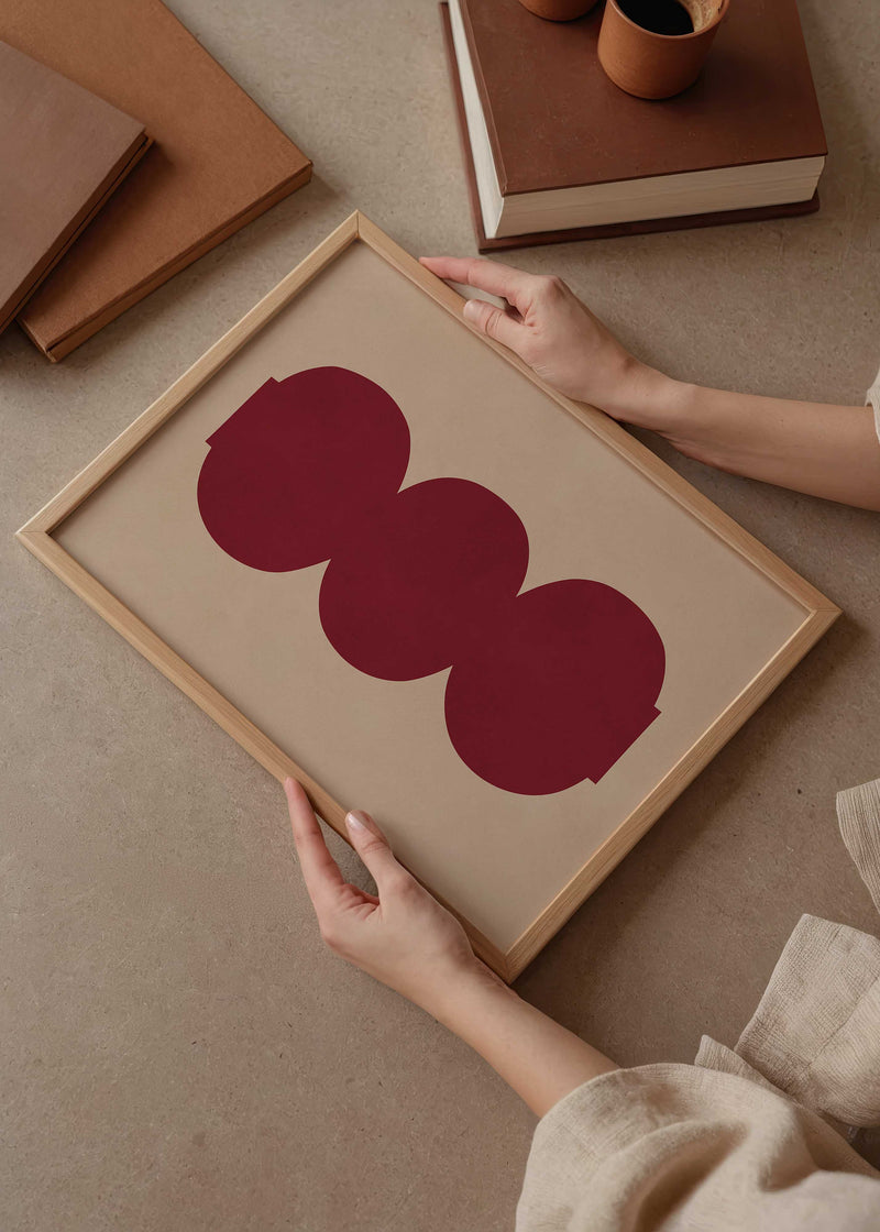 Cuadro geométrico con formas circulares burdeos sobre fondo beige, kudeko.com
