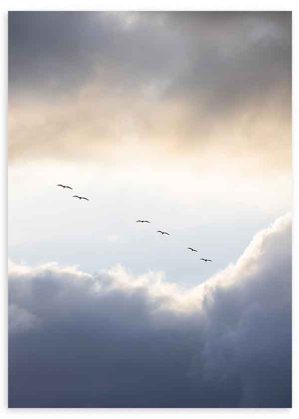 Quadro minimalista de aves a voar entre as nuvens ao amanhecer, em tons suaves, com uma sensação de calma e liberdade. Disponível em kudeko.com