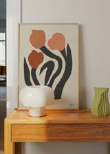 Cuadro con tres tulipanes terracota y salmón, hojas negras alargadas, fondo crema y composición botánica de estilo floral. Disponible en kudeko.com