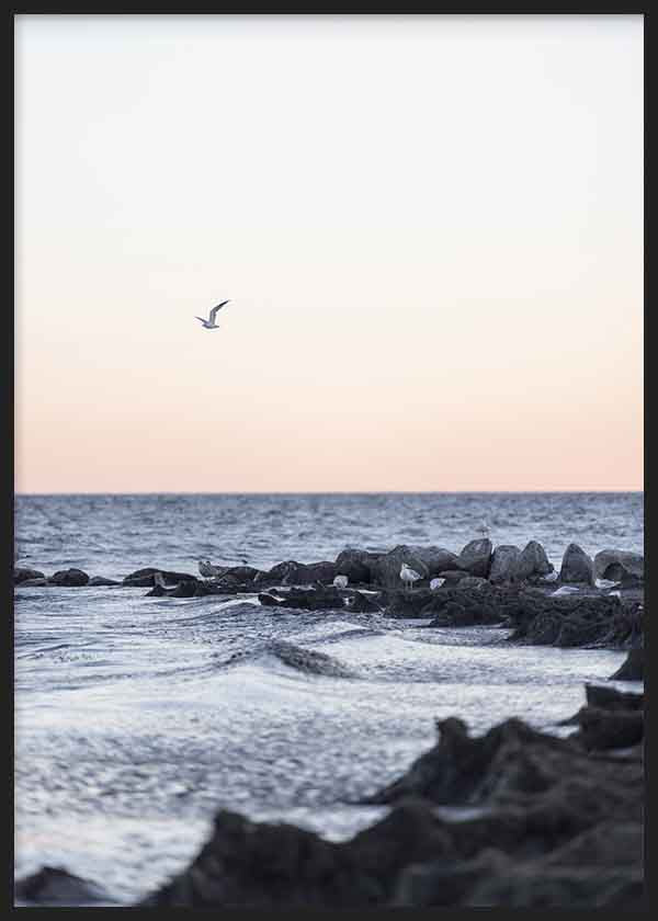 Minimalistisches Wandbild mit Meereslandschaft und einer fliegenden Möwe bei Sonnenuntergang, in sanften Farbtönen, das Ruhe und Freiheit vermittelt. Erhältlich auf kudeko.com