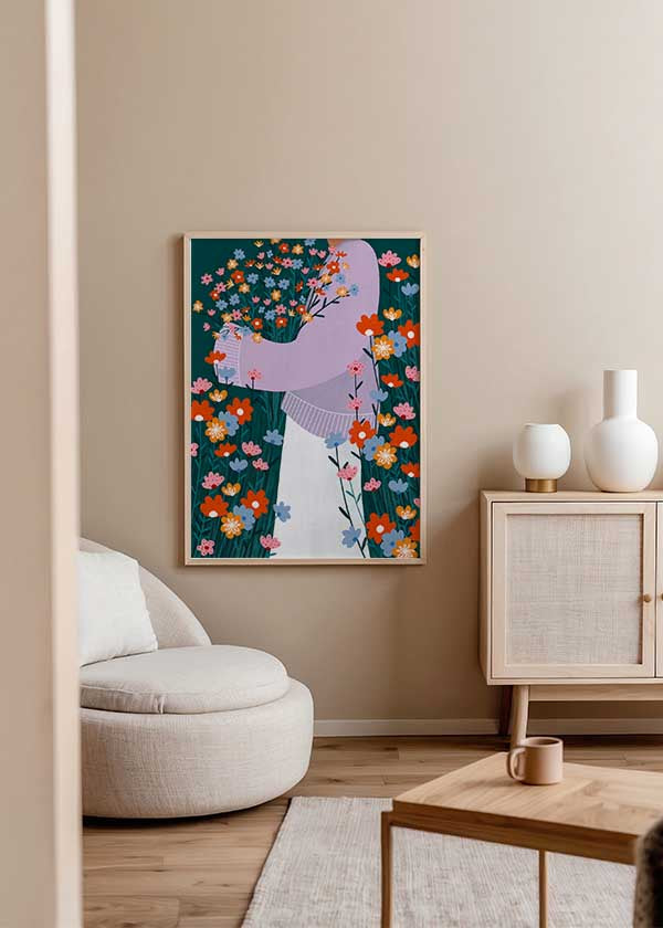 Cuadro ilustrado colorido con mujer sosteniendo ramo de flores silvestres en tonos rojos, azules y rosas, obra de Bea Muller, kudeko.com
