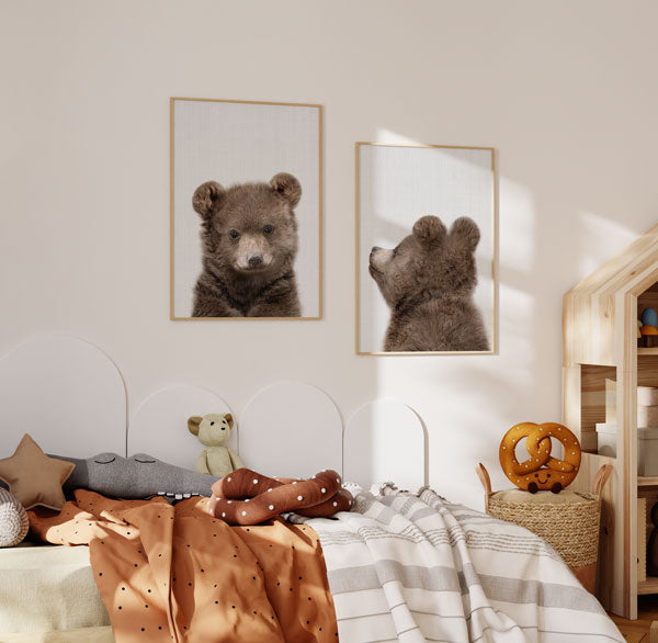 Conjunto de dois quadros com urso bebé castanho e bege, um de frente e outro de perfil, sobre fundo branco texturado, em estilo infantil e suave. Disponível em kudeko.com