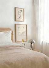 Cuadro con figura humana de líneas negras, pequeña flor en la mano, sol sonriente y fondo crema, de estilo ilustración. Disponible en kudeko.com