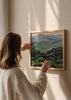 Tableau carré avec collines vertes ondulées, montagnes bleu gris au fond, végétation sombre au premier plan et style nature et paysage équilibré. Disponible sur kudeko.com