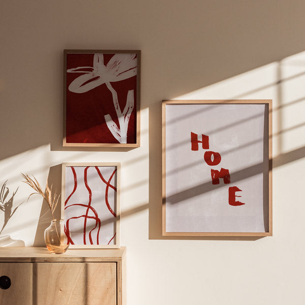 Set aus drei Wandbildern mit dem Wort HOME, organischen Linien und schematischer Blume in Terrakotta, Off-White und Dunkelrot, im abstrakten zeitgenössischen Stil. Erhältlich auf kudeko.com