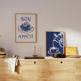 Set aus zwei Wandbildern mit Dessert auf Teller, Schriftzug Bon Appétit, Kaffeekanne beim Einschenken von Kaffee, in Blau und Weiß, im illustrativen Retro-Stil für Küche oder Esszimmer. Erhältlich auf kudeko.com