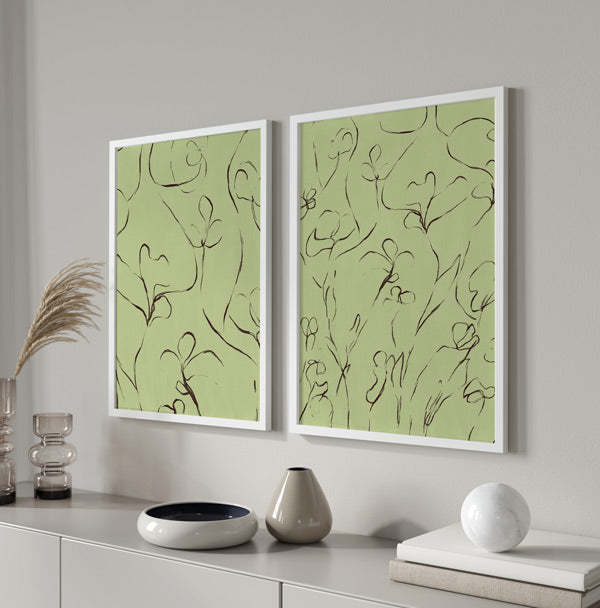 Conjunto de dos cuadros con flores de líneas sinuosas, tallos finos y fondo verde suave, en negro y estilo minimalista. Disponible en kudeko.com