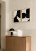 Conjunto de dois quadros com formas abstratas curvas em preto sobre fundo bege claro, composição contemporânea contrastante de estilo minimalista para decoração de parede. Disponível em kudeko.com