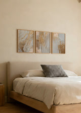 Set aus drei gerahmten Wandbildern mit abstrakter Marmoreffekt-Komposition, fließenden Maserungen, mineralischen Texturen und Farbtönen in Gold, Beige, Sand und Weiß, im modernen abstrakten Stil. Erhältlich auf kudeko.com